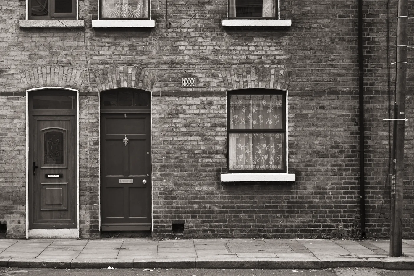 The front elevation of a brick terraced house, graded almost cold